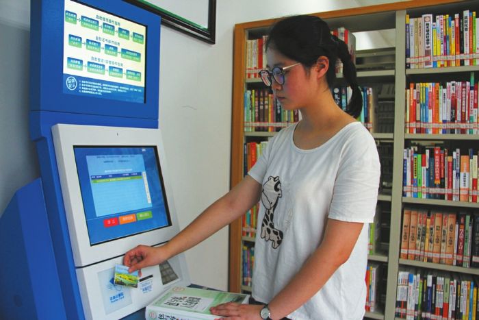 一市民正刷卡借书。
