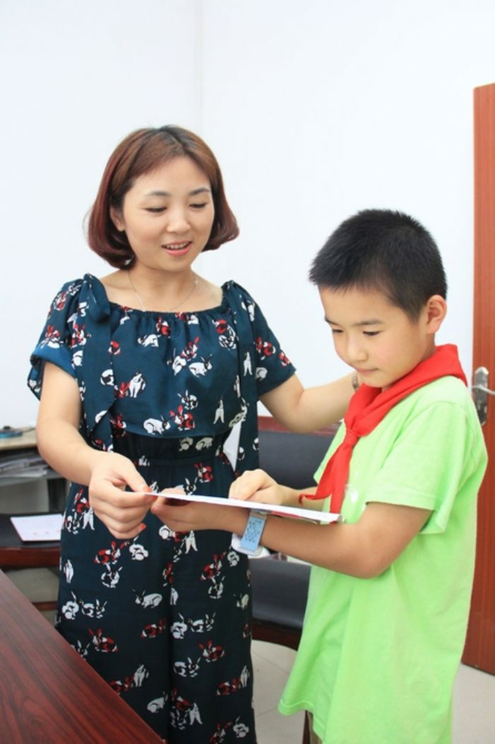 小学生向老师赠送贺卡。
