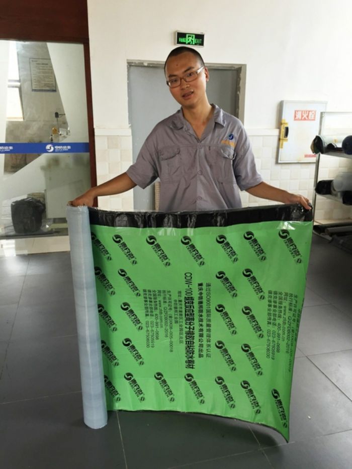 工人展示蠕变型高分子自粘防水卷材
