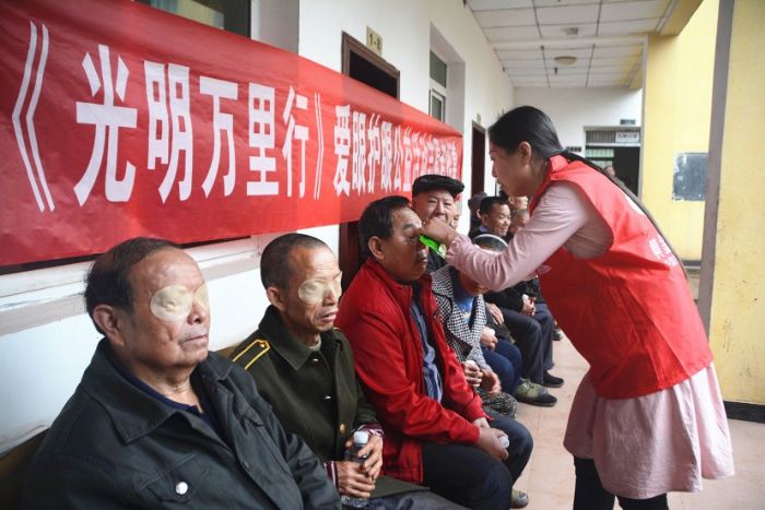 志愿者正在为老人贴眼贴。
