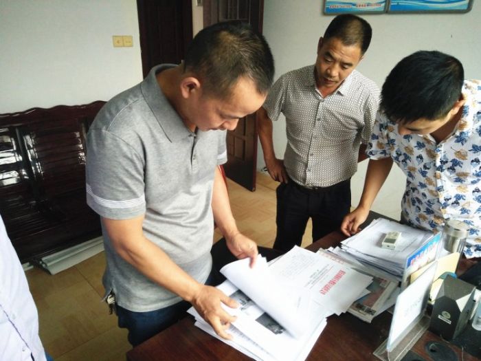 工作人员在检查农村生活垃圾治理台账。
