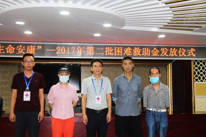 工作人员与特困群众代表合影。
