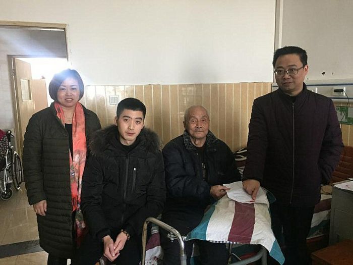 工作人员与老人合影。
