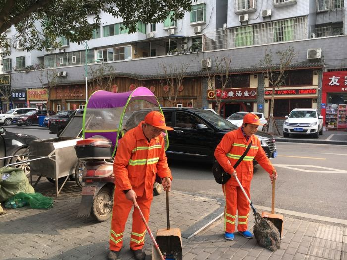 张国强、周素辉夫妻正在清扫街道。

