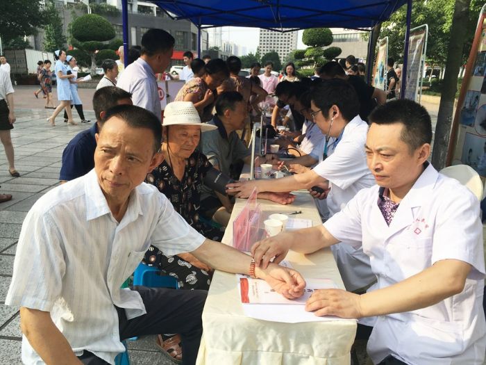 专家们为市民测量血压、诊断病情。
