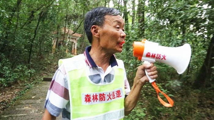 郑隆明对林区进行防火宣传。
