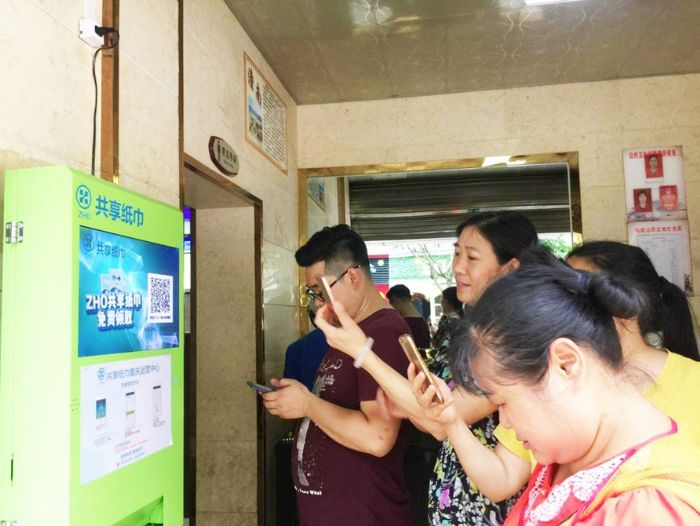 市民正在扫二维码领取纸巾。
