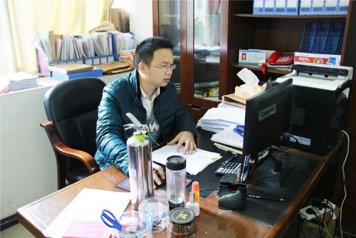 周波在办公室整理扶贫资料。
