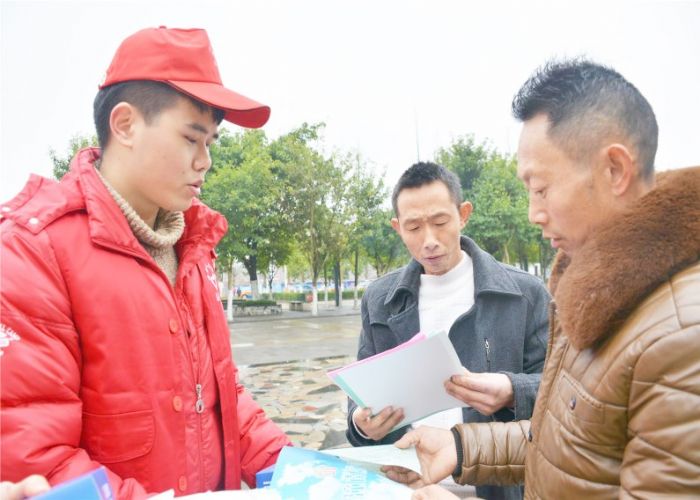 志愿者为旅客发放列车时刻表。
