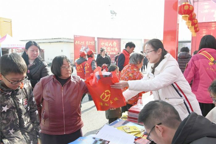 ▲工作人员向返乡市民送上新春礼包。
