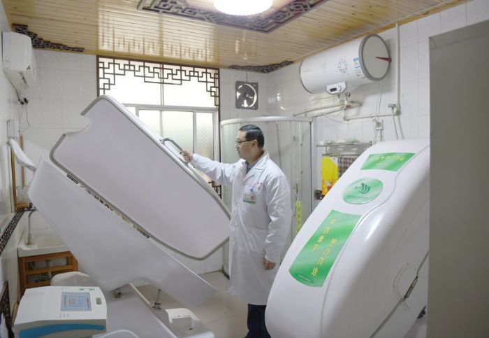 郑才高认真检查“自动中药熏蒸器。”
