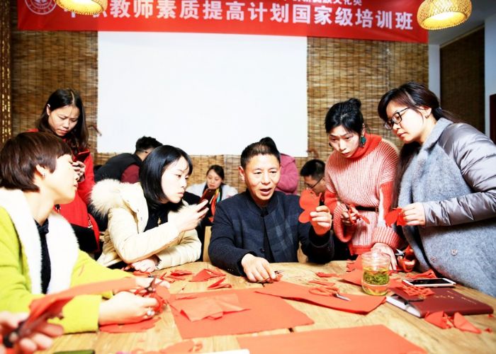 指导参加教委国培活动的学员剪纸。
