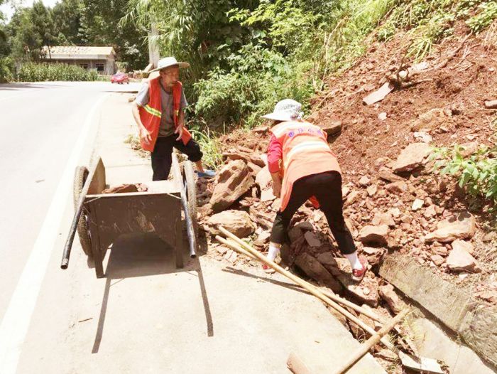 工作人员清理路边的碎石。