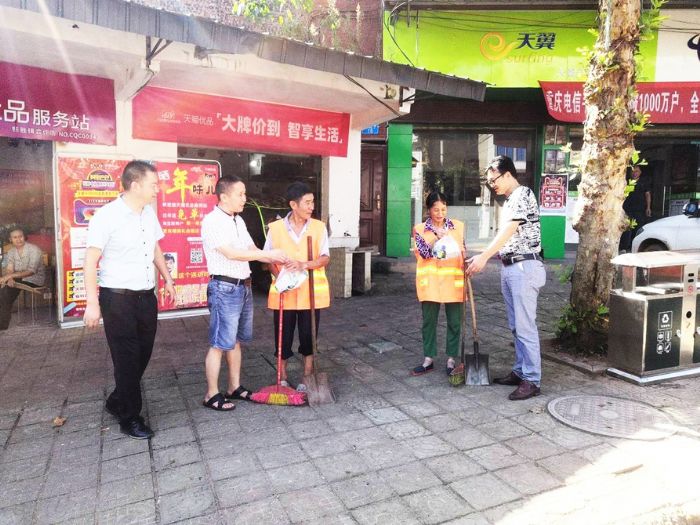 人大代表将慰问物品送到环卫工人手中。
