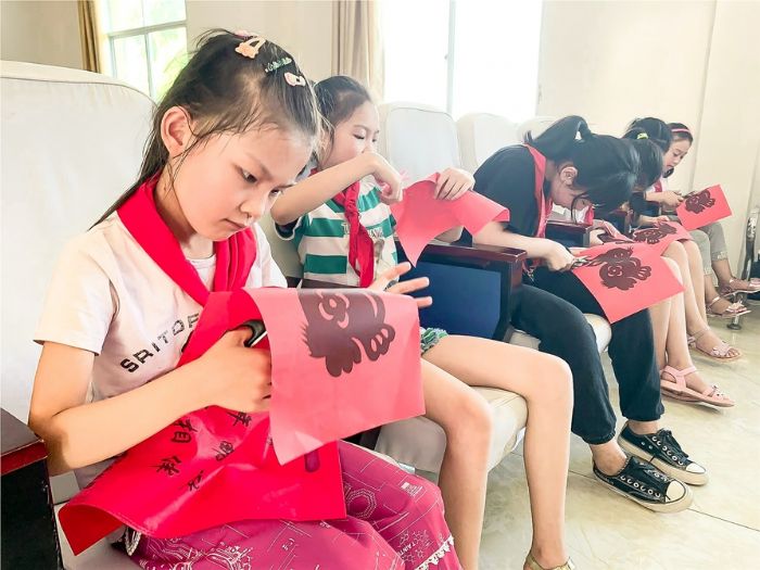 孩子们正学习剪纸。
