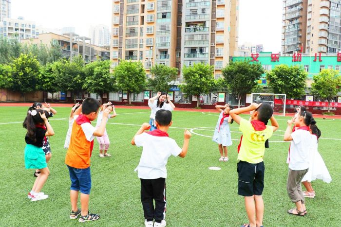 朝阳小学的绿茵场上，徐静带着学生们跳单词舞
