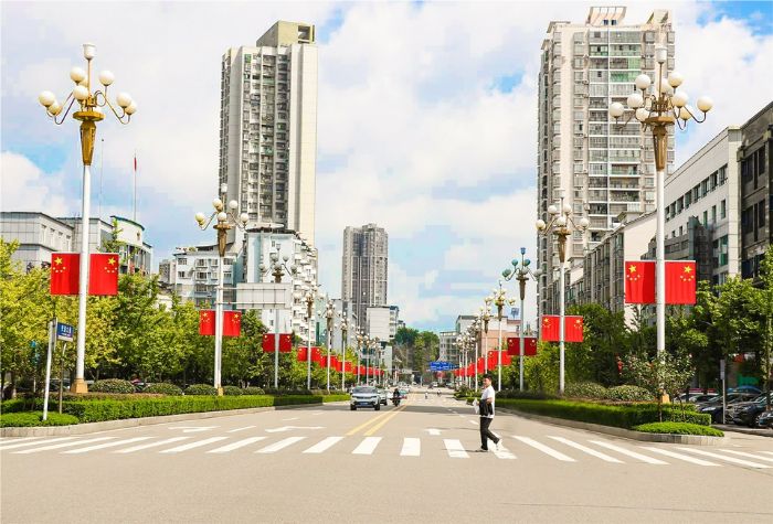 潼南各个主干道路灯杆悬挂起国旗
