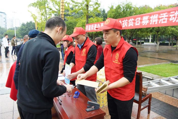 梓潼街道志愿者向市民宣传扶贫助困相关政策
