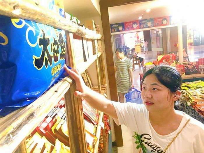 游客在洪崖洞选购太安鱼调料。
