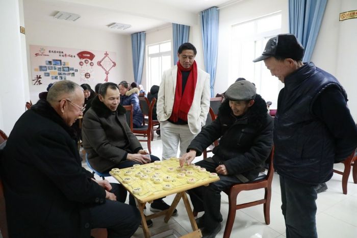 东风社区养老服务站内，几位老人下棋娱乐身心。
