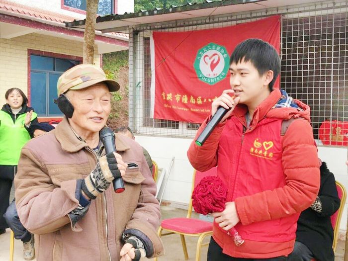 志愿者和老人们玩击鼓传花游戏
