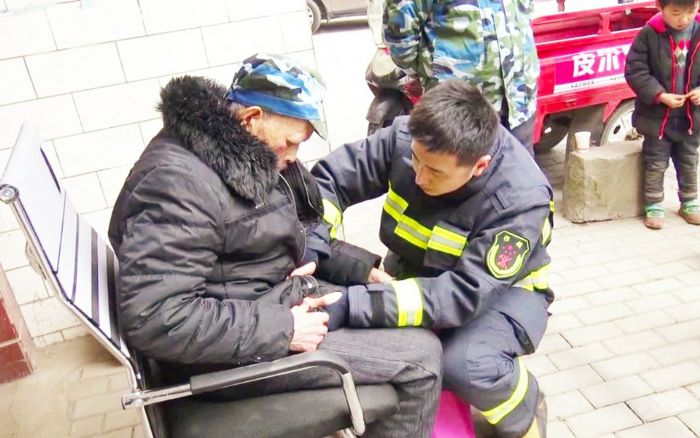 消防员为老人整理衣服
