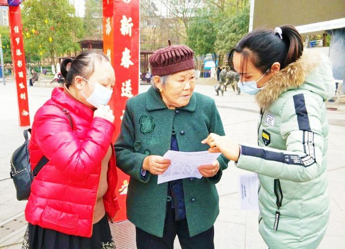 社区工作人员向市民宣传出行戴口罩的重要性。
