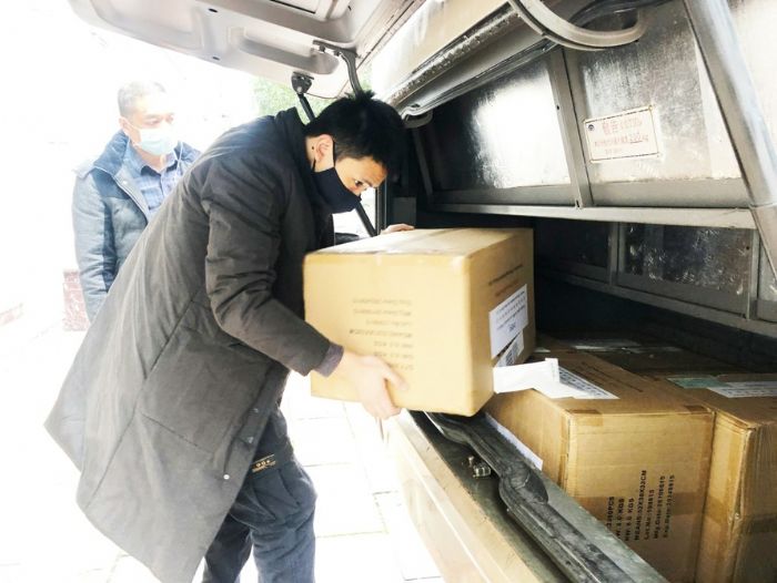 ◀10万只口罩被搬运到指定存放点。
