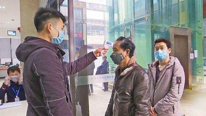 工作人员对前来办事的人员进行体温检测
