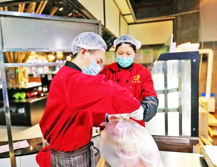 工作人员对顾客的外带食品打包
