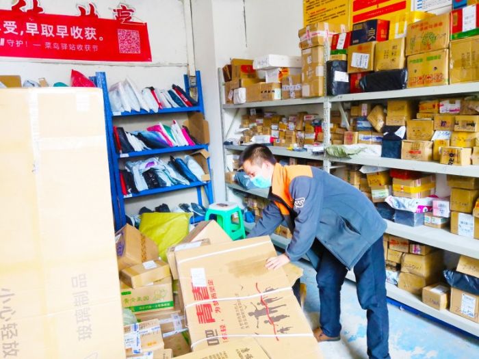 快递小哥在整理囤积的快件。
