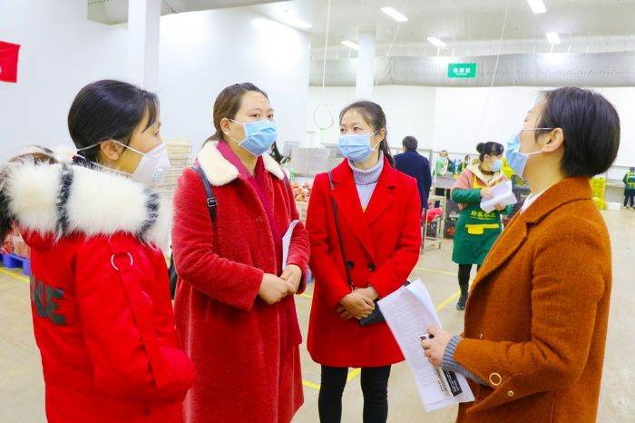 向务工人员介绍工作情况。
