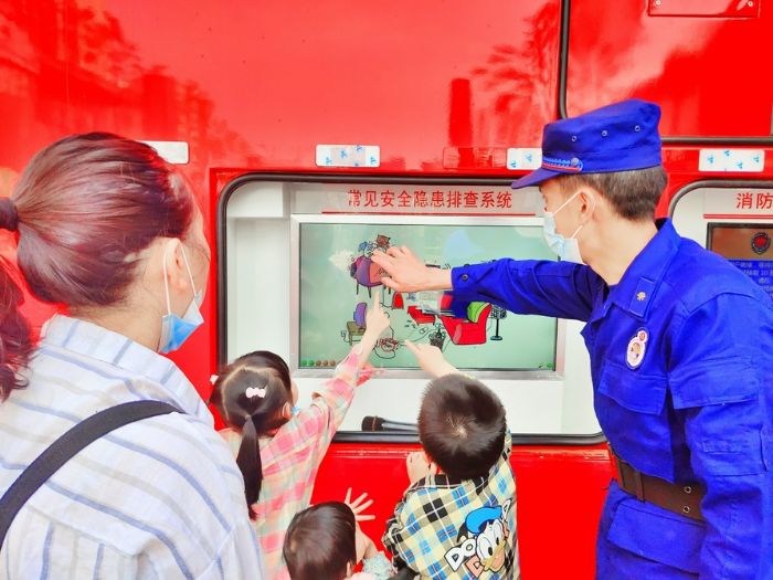 消防员利用消防宣传车向市民讲解安全隐患排查。
