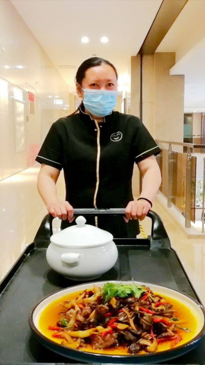　　5月14日，科宇酒店餐饮部农民工代大姐准备给客人上菜。
