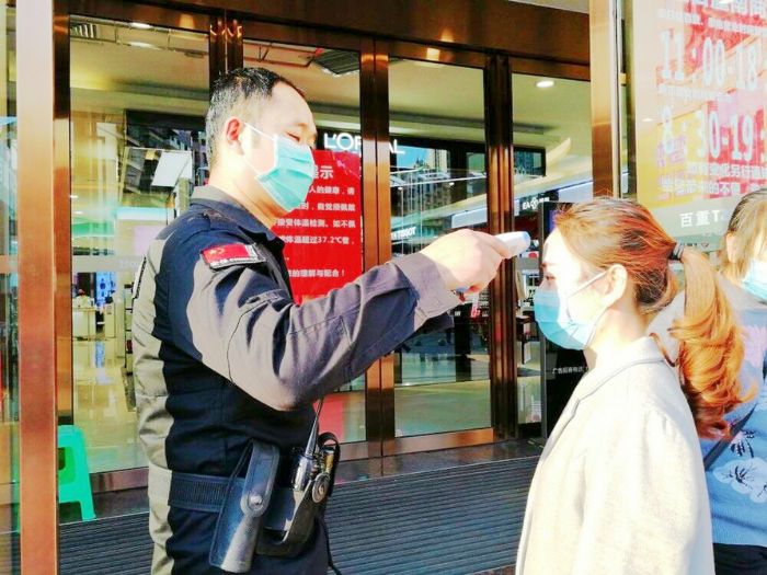 重百工作人员为顾客测量体温。全媒体记者罗列摄
