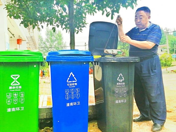 高桥村一村民在垃圾回收点分类倒放垃圾。

