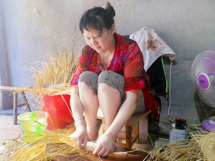 曹前秀在编织棕扇。
