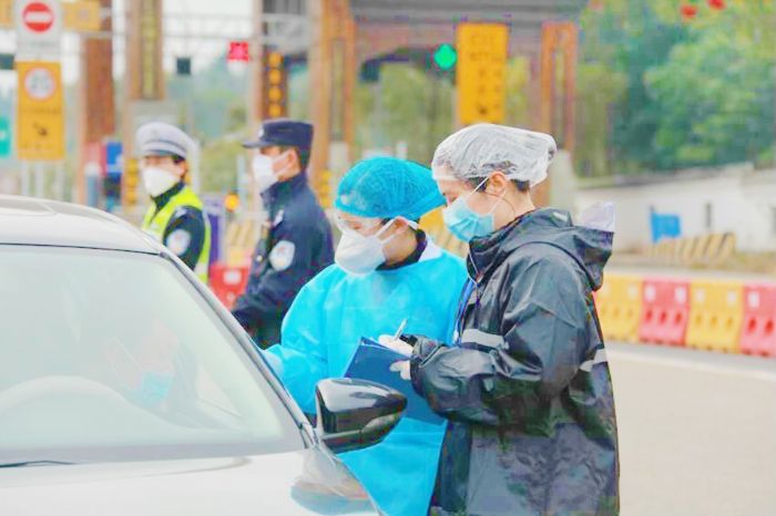 尤源（右）在高速路口排查车辆。
