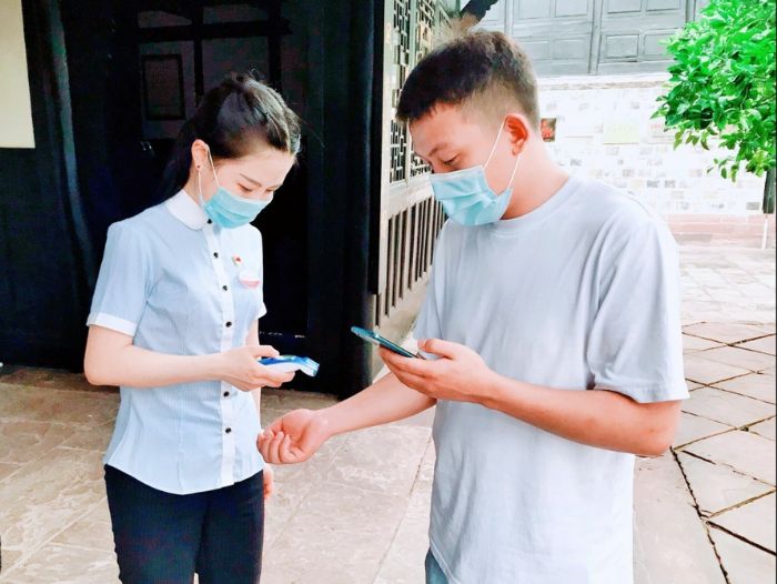 李解（左一）为游客测量体温。
