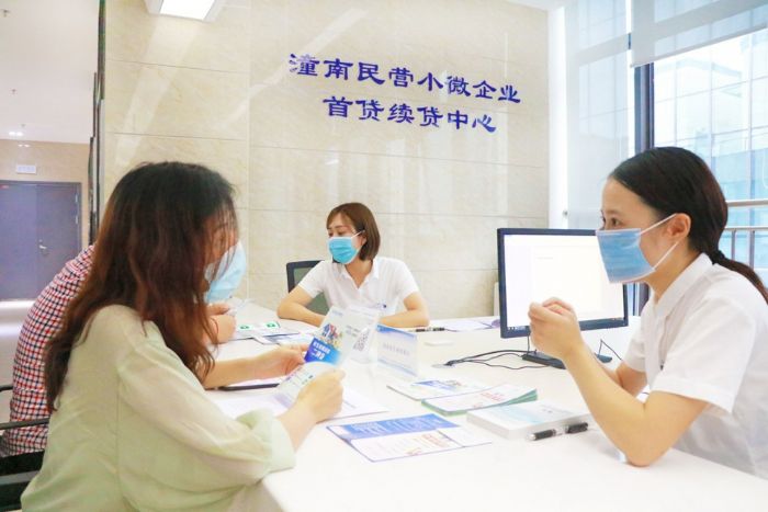 工作人员向客户介绍信贷政策。
