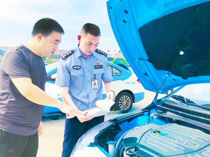 车管所工作人员上门为出租车办理注册登记业务。
