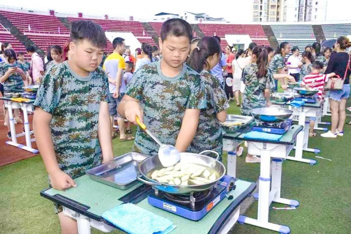 孩子们学习炒菜。
