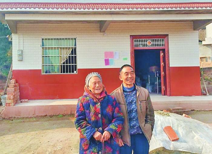 谭继明和母亲在新房前合影。
