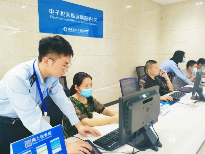 ▲工作人员指导市民便捷办税。
