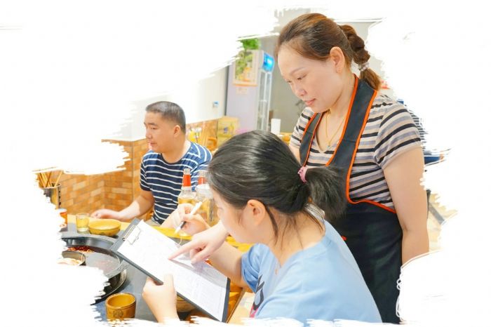 ▼餐厅服务员帮助顾客点餐。。
