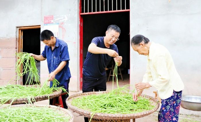 黎晓春帮助村民晒菜。
