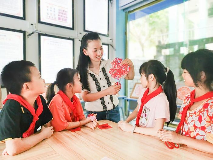 李蓬春给孩子们上剪纸课。
