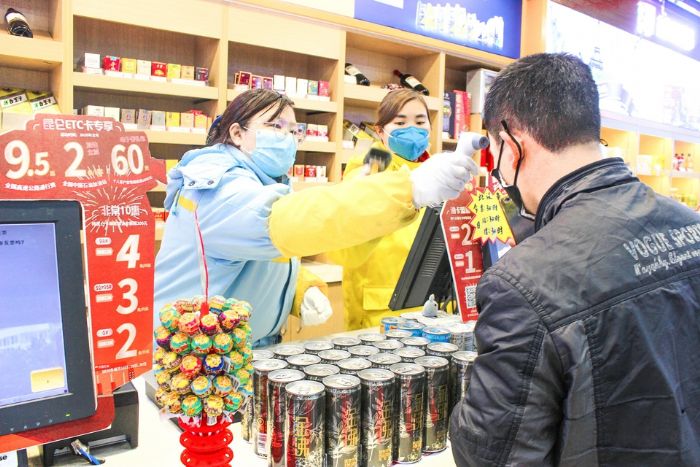王筱为进站顾客测量体温。
