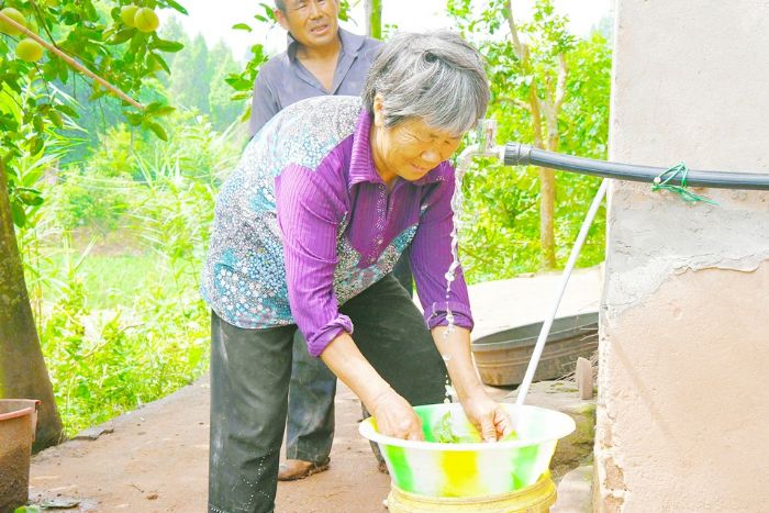 居民正在用自来水洗菜。

