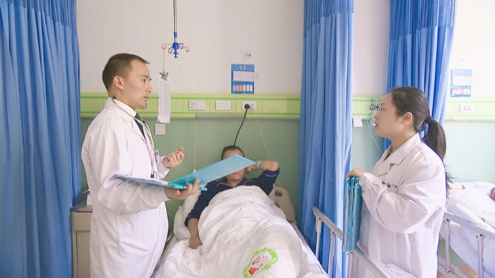 周万洪了解患者病情。
